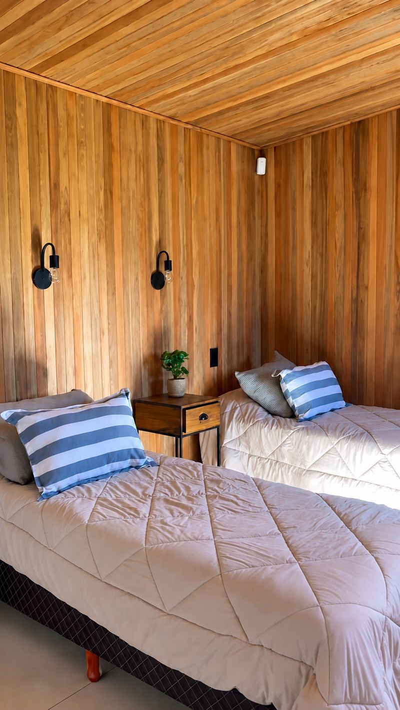 Habitación con dos camas y paredes de madera